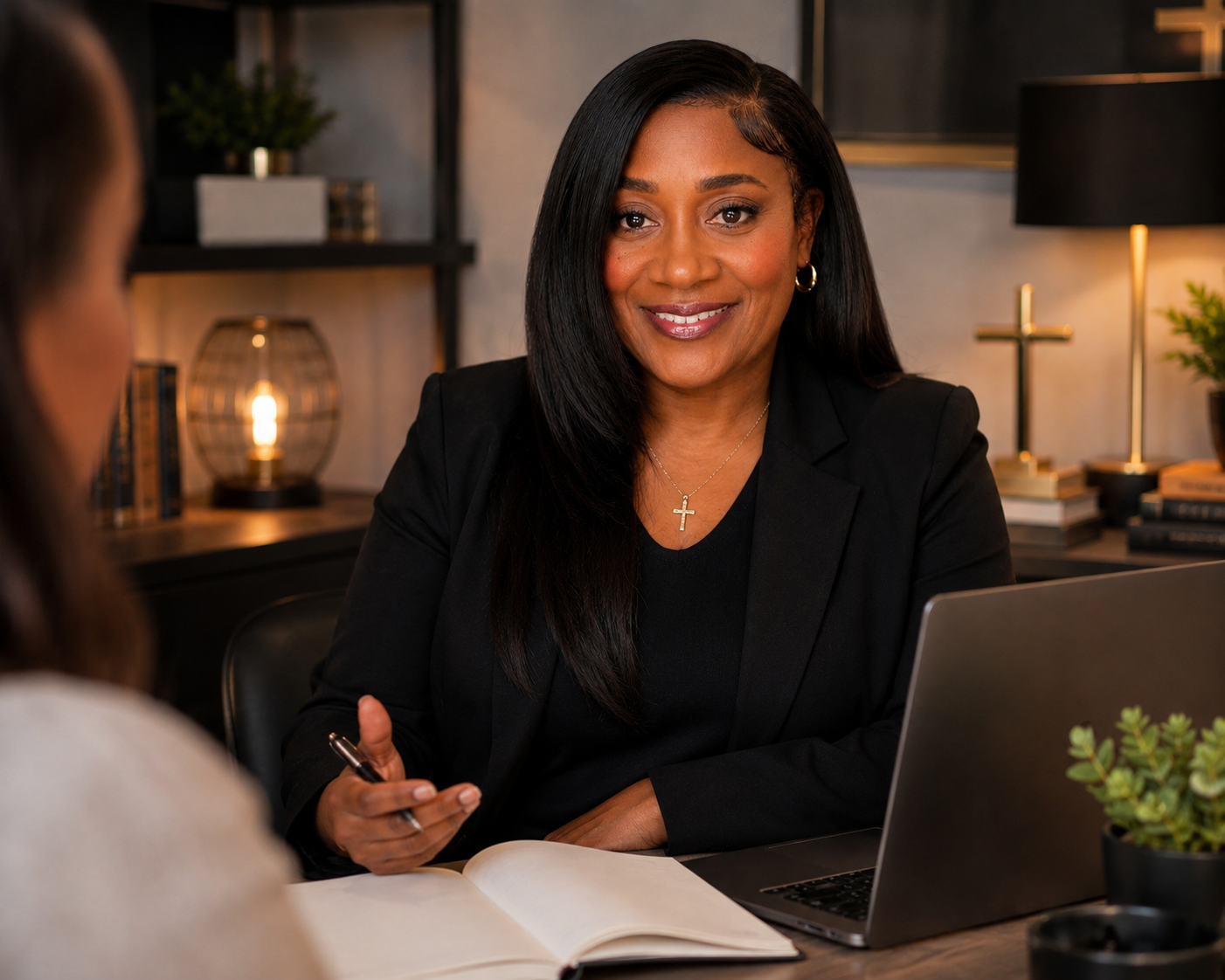 Felecia Blackmon consulting with a client beside a laptop.